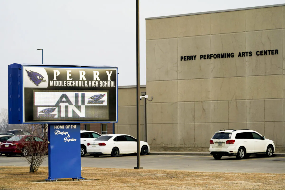 FILE - Vehicles are seen in a parking lot outside of Perry High School following a shooting at the school, Jan. 5, 2024, in Perry, Iowa. An Iowa principal who put himself in harm’s way to protect students during a school shooting earlier this month died Sunday, Jan. 14, 2024, a funeral home confirmed. Caldwell Parrish Funeral Home & Crematory confirmed the death of Perry High School Principal Dan Marburger after the family announced it on a GoFundMe page. (AP Photo/Charlie Neibergall, file)