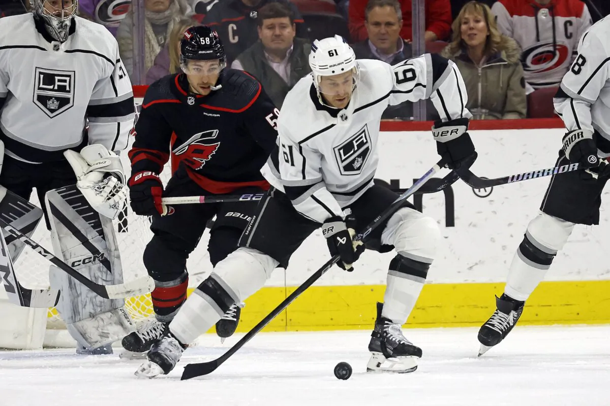 Los Angeles Kings' Trevor Lewis (61) protects the puck from Carolina Hurricanes' Michael Bunting (58) during the first period of an NHL hockey game in Raleigh, N.C., on Jan. 15, 2024. (Karl B DeBlaker/AP Photo)