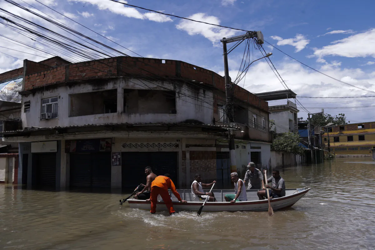 Firefighters evacuate residents through a flooded street after deadly rainfall in Belford Roxo, Brazil, on Jan. 15, 2024. (Bruna Prado/AP Photo)