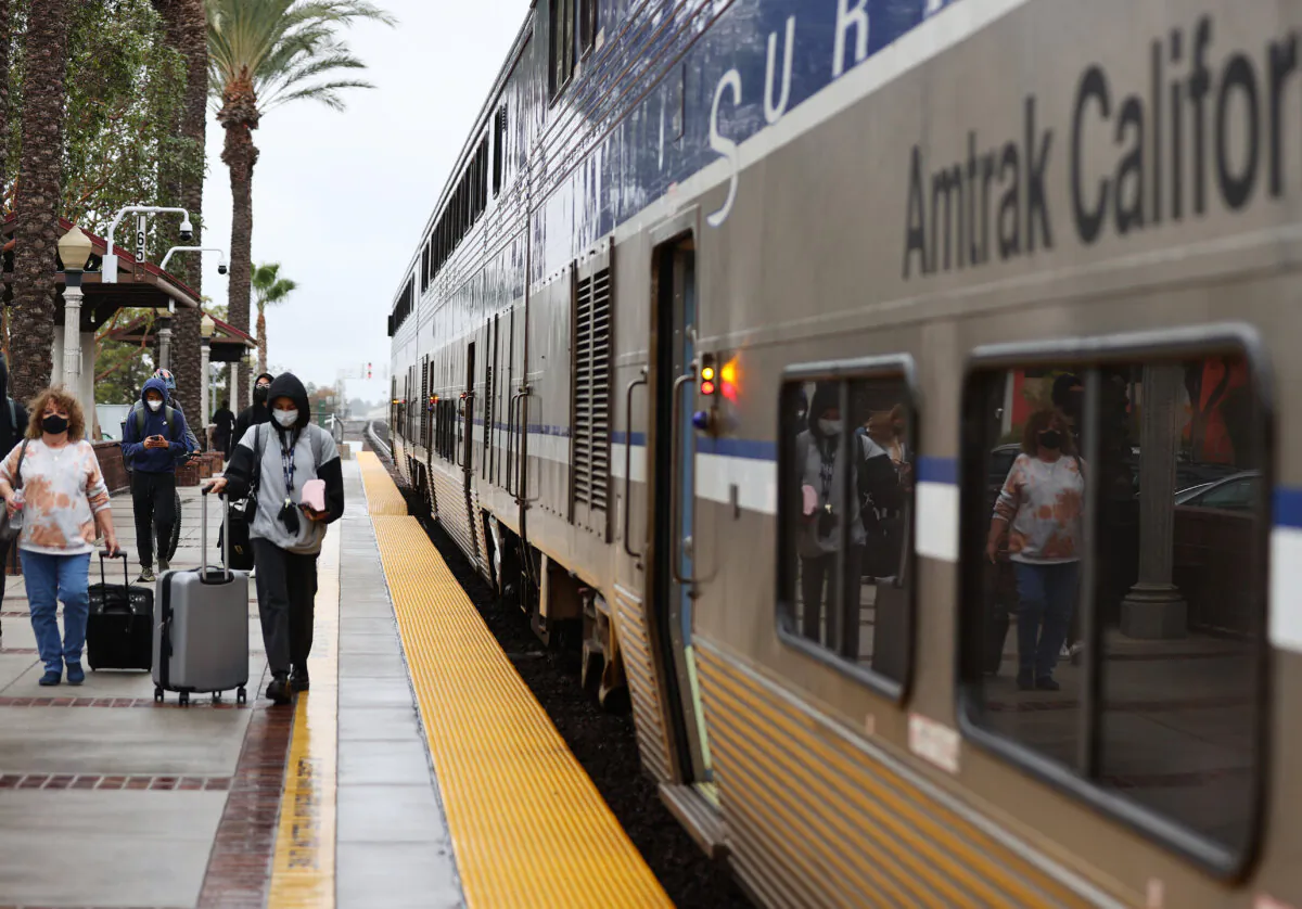 Passengers depart an Amtrak train during a station stop in Fullerton, Calif., on Dec. 9, 2021. (Mario Tama/Getty Images)