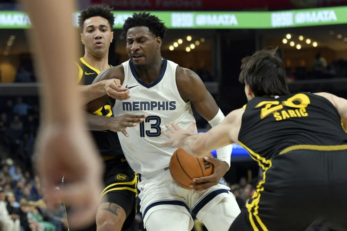 Memphis Grizzlies forward Jaren Jackson Jr. (13) drives between Golden State Warriors forwards Trayce Jackson-Davis (L) and Dario Saric (20) in the second half of an NBA basketball game in Memphis, Tenn., on Jan. 15, 2024. (Brandon Dill/AP Photo)