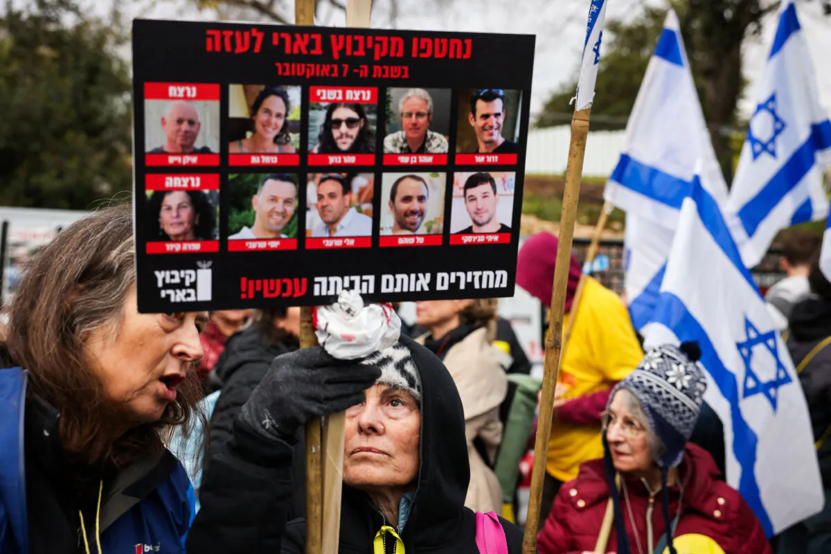 Protesters lift placards and national flags during a rally demanding the release of Israelis taken hostage a hundred days earlier by Hamas on Oct. 7, outside the Israeli Parliament in Jerusalem on Jan. 15, 2024. (Ahmad Gharabli/AFP via Getty Images)