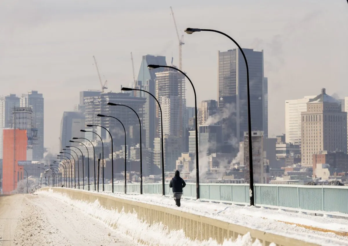 A person jogs next to a backdrop of the Montreal skyline as ice fog rises off the St. Lawrence River in Montreal, on Jan. 22, 2022. (The Canadian Press/Graham Hughes)
