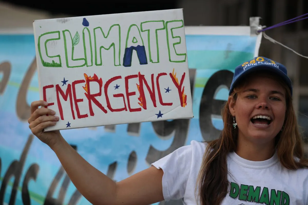 A woman holds a sign that reads "climate emergency" in a climate change protest in Australia on Jan. 17, 2020. (Photo by Joe Raedle/Getty Images)