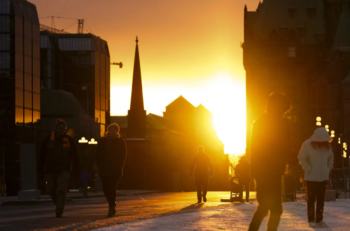 People visit Parliament Hill during sunset in Ottawa on Dec. 19, 2023. (The Canadian Press/Sean Kilpatrick)