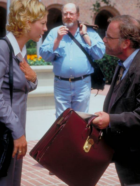 man with briefcase talking to woman in grey suit in KRIPPENDORF'S TRIBE