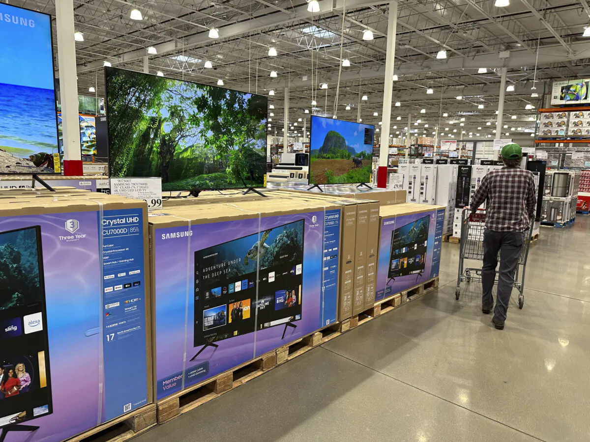 A shopper passes a display of big-screen televisions in a Costco warehouse in Sheridan, Colo., on Jan. 11, 2024. (David Zalubowski/AP Photo)