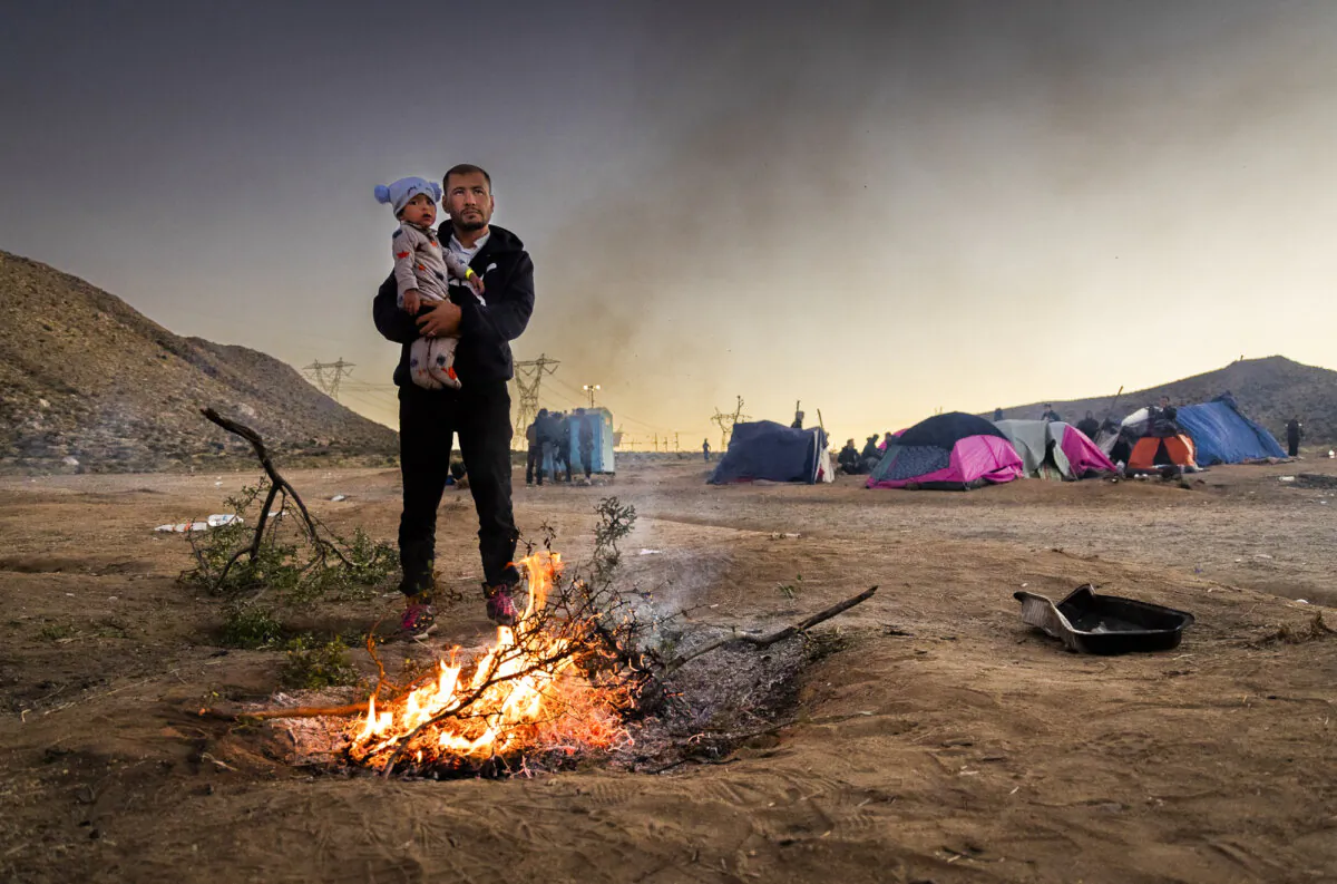 Allhadad Mujtaba, a former communications officer in the Afghan National Army, stands next to a fire on a cold night near Jacumba, Calif., on Dec. 5, 2023. (John Fredricks/The Epoch Times)