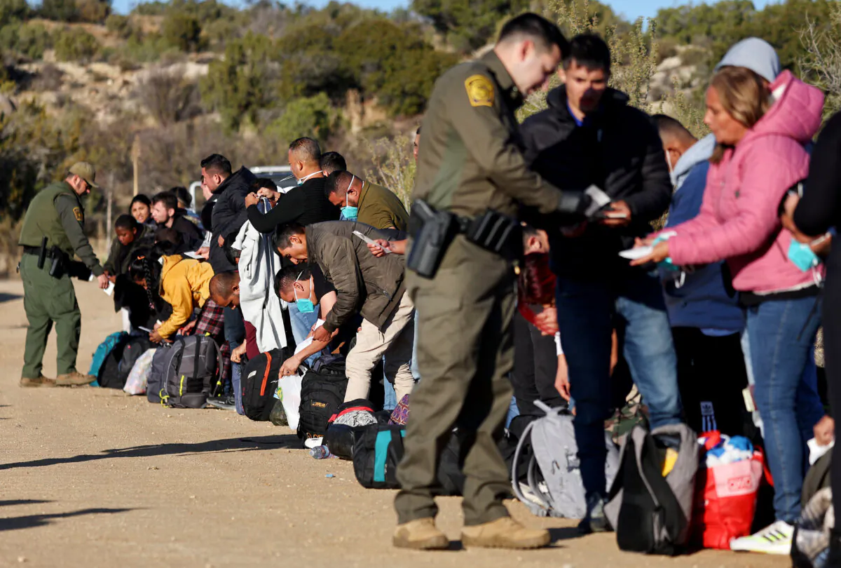 U.S. Border Patrol agents check identification papers of illegal immigrants before they are transported to a Border Patrol processing center in Jacumba Hot Springs, Calif., on Dec. 1, 2023. (Mario Tama/Getty Images)