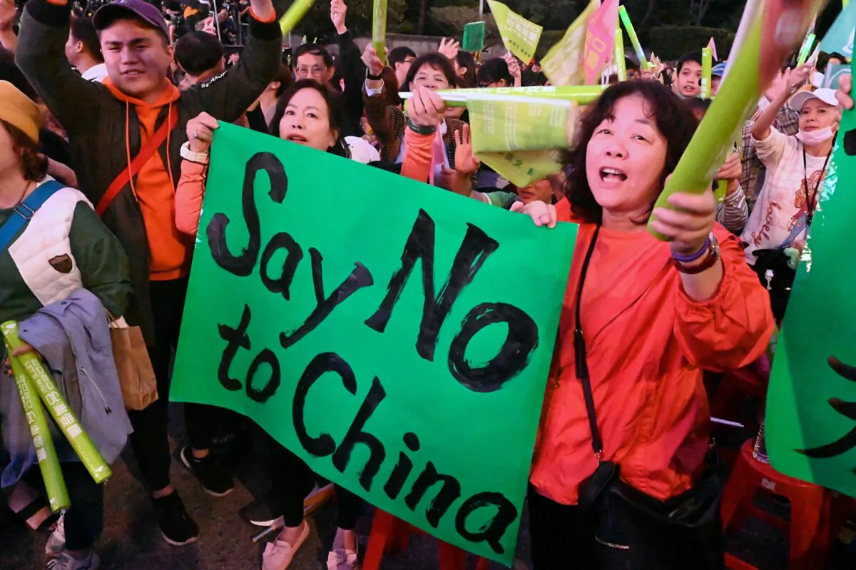 Supporters of Taiwan's President Tsai Ing-wen from the ruling Democratic Progressive Party (DPP) display a placard during a rally in Taipei on Jan. 10, 2020, ahead of the Jan. 11 presidential and parliamentary elections. (Sam Yeh/AFP)