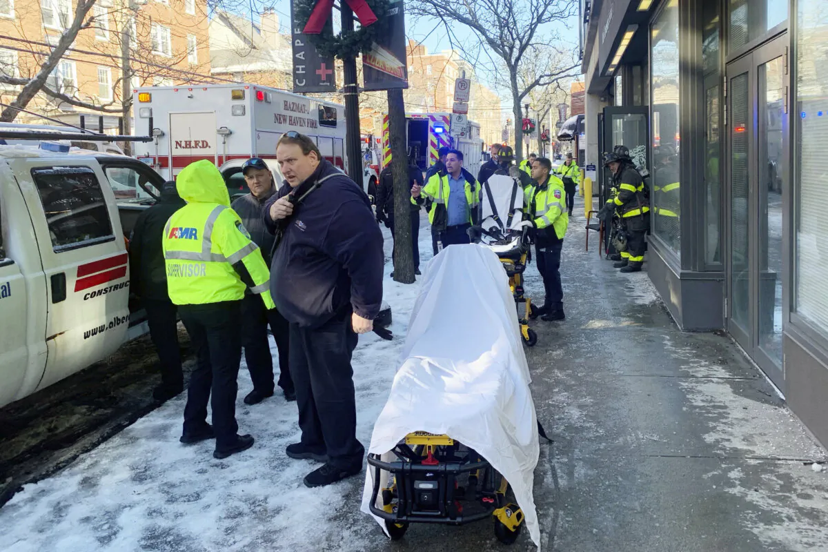 Ambulance and New Haven CT Fire Department personnel respond to a Yale University-owned building where nine construction workers and five Yale employees who were renovating it were hospitalized for carbon monoxide poisoning, in New Haven, Conn., on Jan. 17, 2024. (Rick Fontana/New Haven Emergency Management via AP)