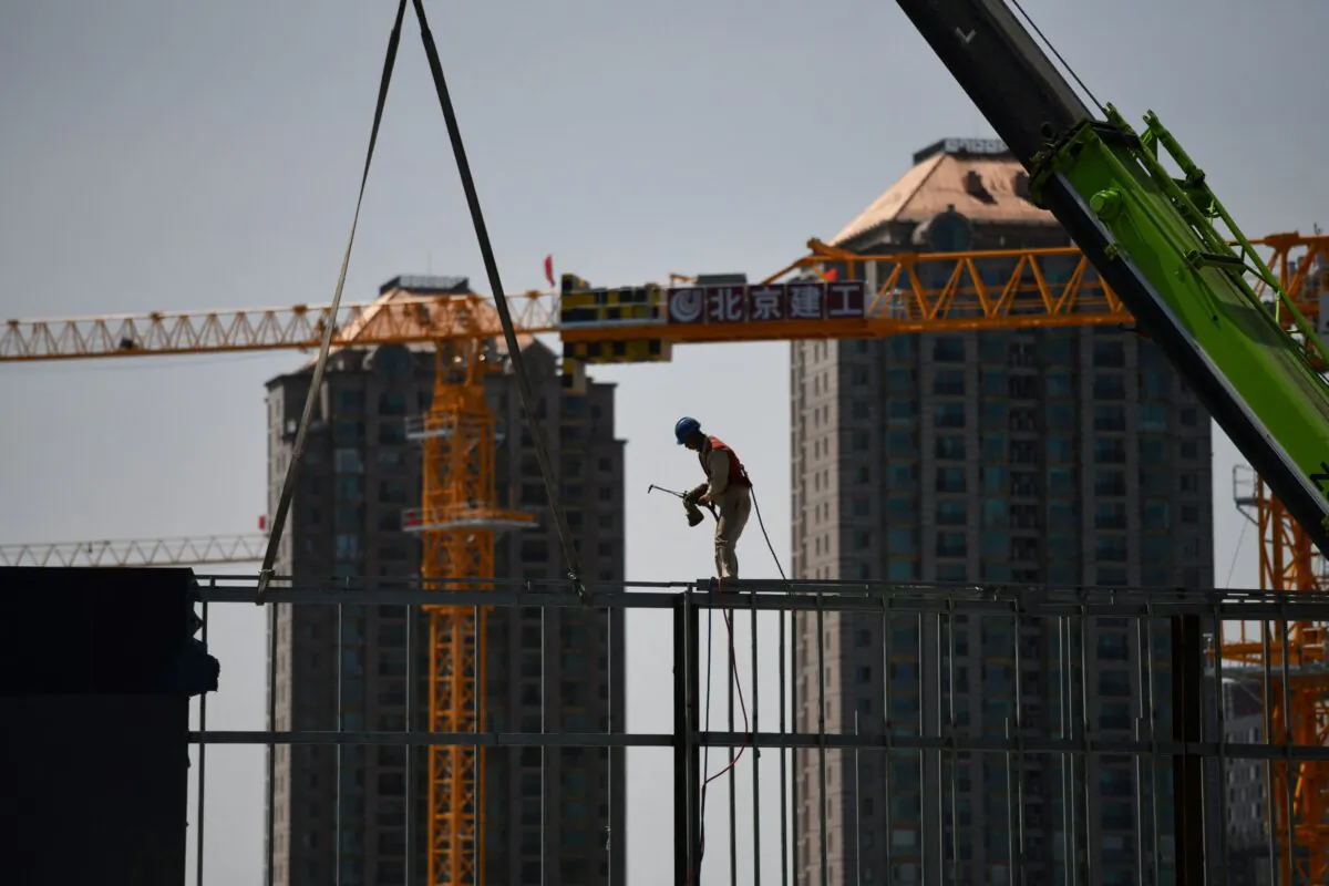 A worker prepares to weld a steel structure at a construction site in Beijing on May 8, 2021. (Greg Baker/AFP via Getty Images)