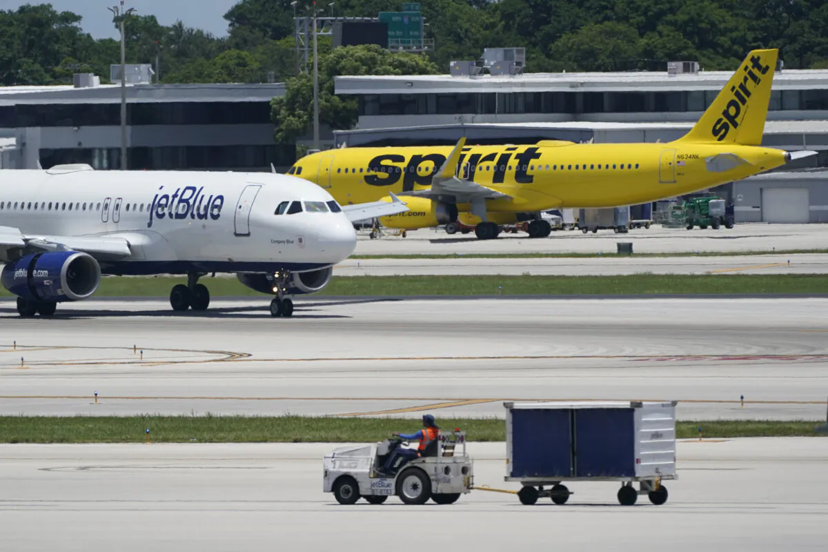 A JetBlue Airways Airbus A320 (L), passes a Spirit Airlines Airbus A320 as it taxis on the runway at the Fort Lauderdale-Hollywood International Airport in Fort Lauderdale, Fla., on July 7, 2022. (Wilfredo Lee/AP Photo)
