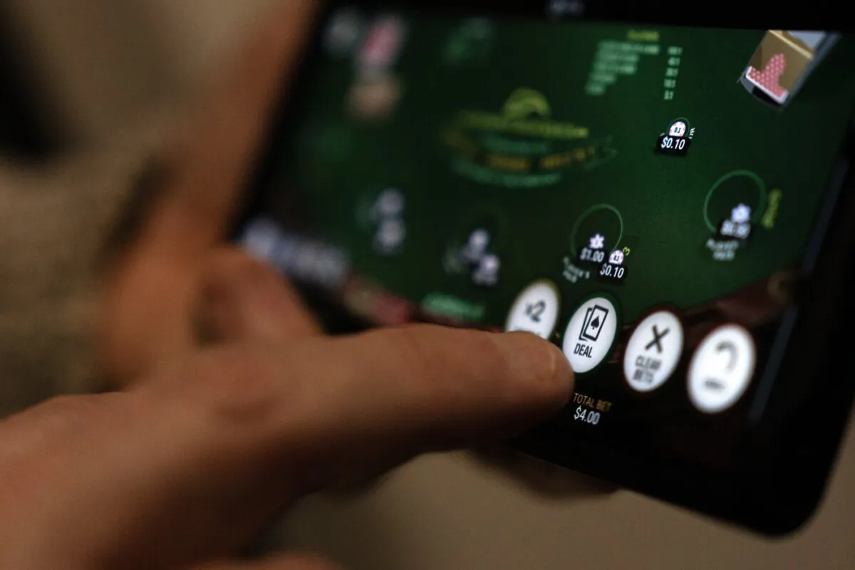 A "deal" button on a casino app is shown on a smartphone in a photo illustration made in Toronto, on Jan. 17, 2024. (The Canadian Press/Giordano Ciampini)