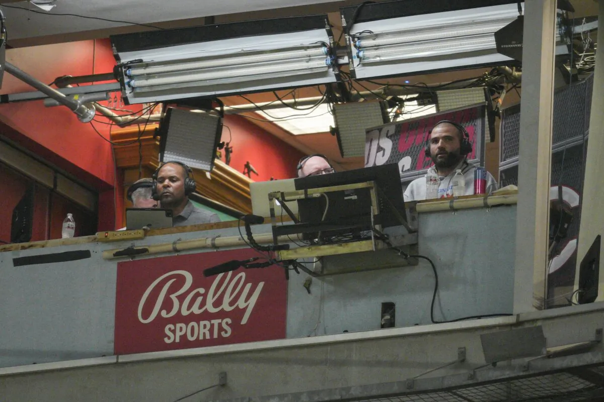 Cincinnati Reds' Joey Votto (R) sits in the broadcast booth with John Sadak (CR) and Barry Larkin (CL) during a baseball game against the St. Louis Cardinals in Cincinnati on Aug. 31, 2022. (Jeff Dean/AP Photo)