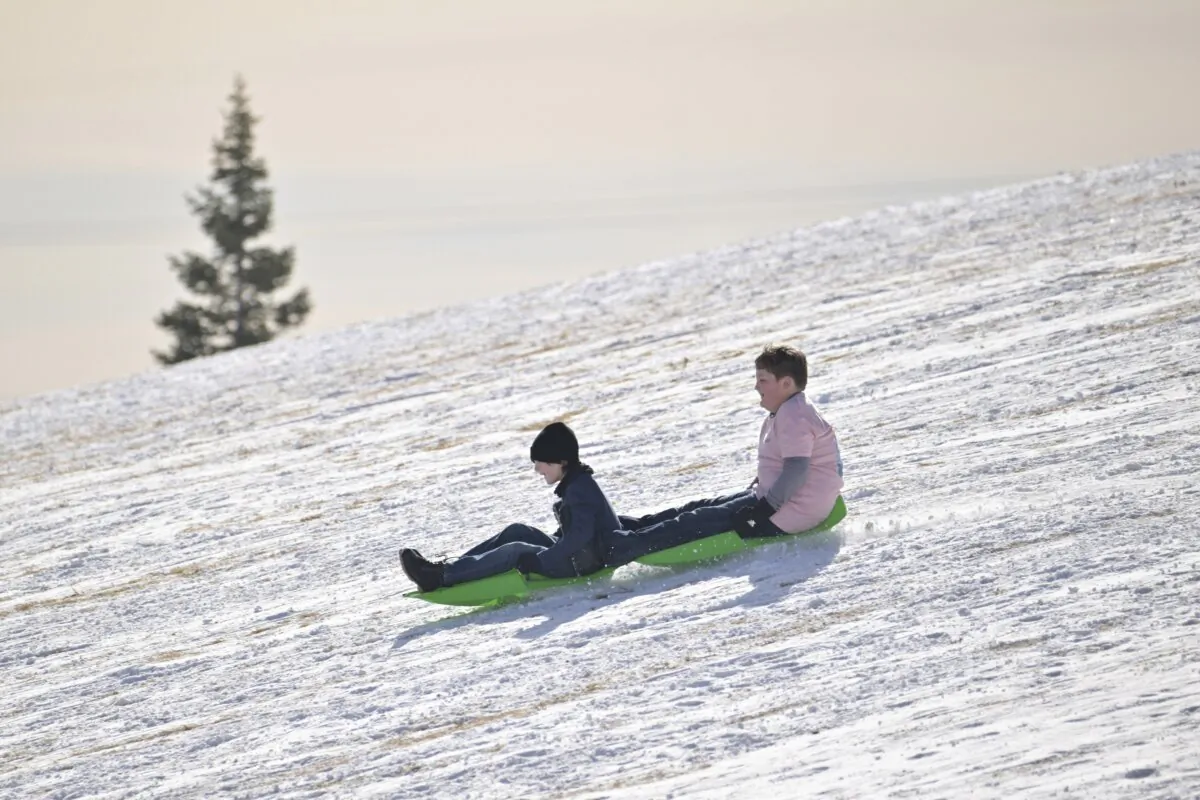 Reid Rutledge, 9, from Florida (L) sleds with his brother Tristen, 10, at Ruby Hill Park in Denver on Jan. 17, 2024. (Hyoung Chang/The Denver Post via AP)