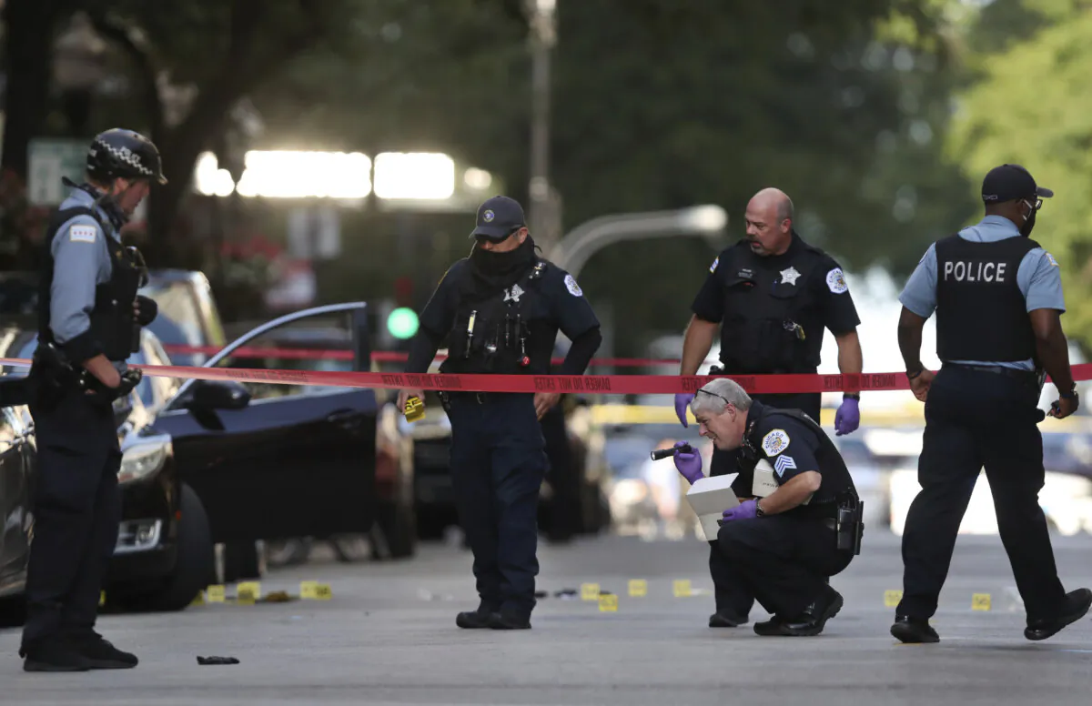 Chicago police investigate the scene of a shooing in Chicago on Aug. 4, 2020. (Chris Sweda/Chicago Tribune via AP)