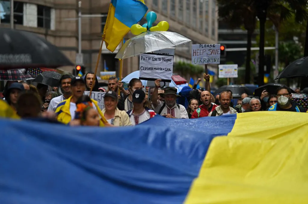 Members of the Australian-Ukrainian community carry a Ukrainian flag during a protest against Russia's invasion of Ukraine, in Sydney on Feb. 26, 2022. (Steven SAPHORE/AFP via Getty Images)