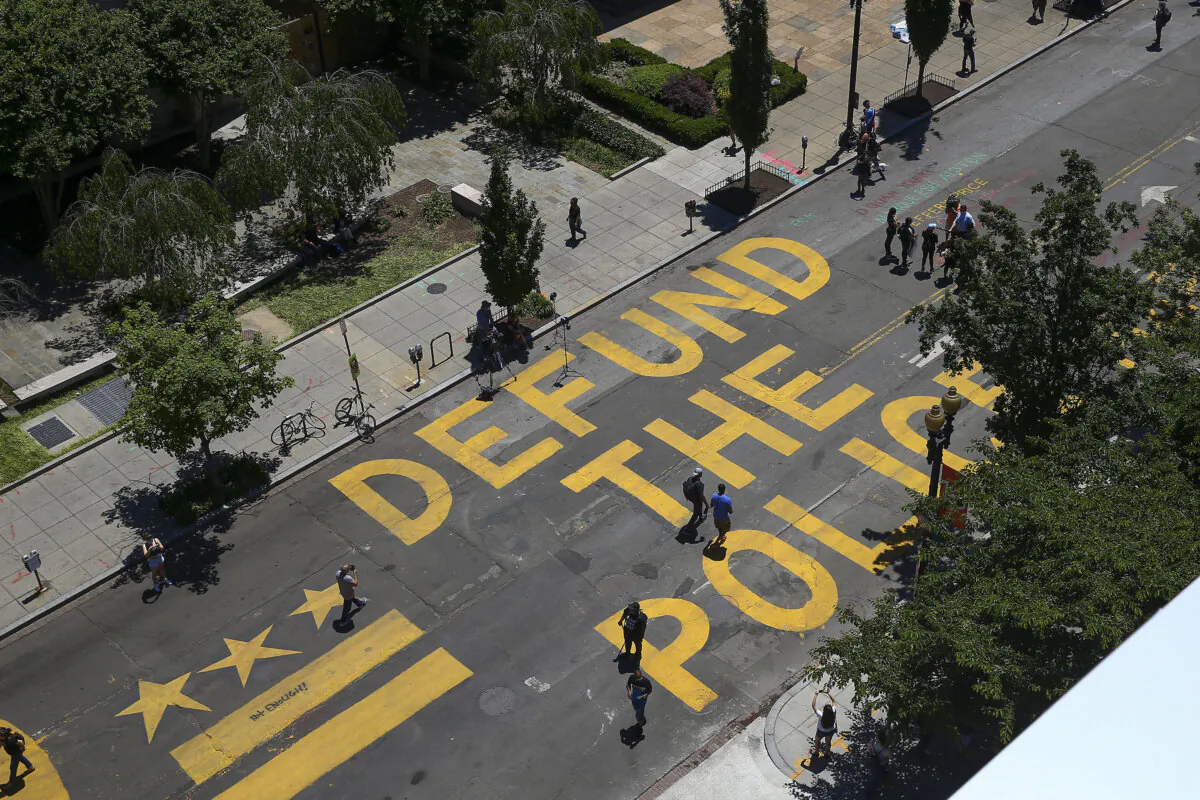 People walk down 16th Street after “Defund the Police” was painted on the street near the White House on June 8, 2020. (Tasos Katopodis/Getty Images)