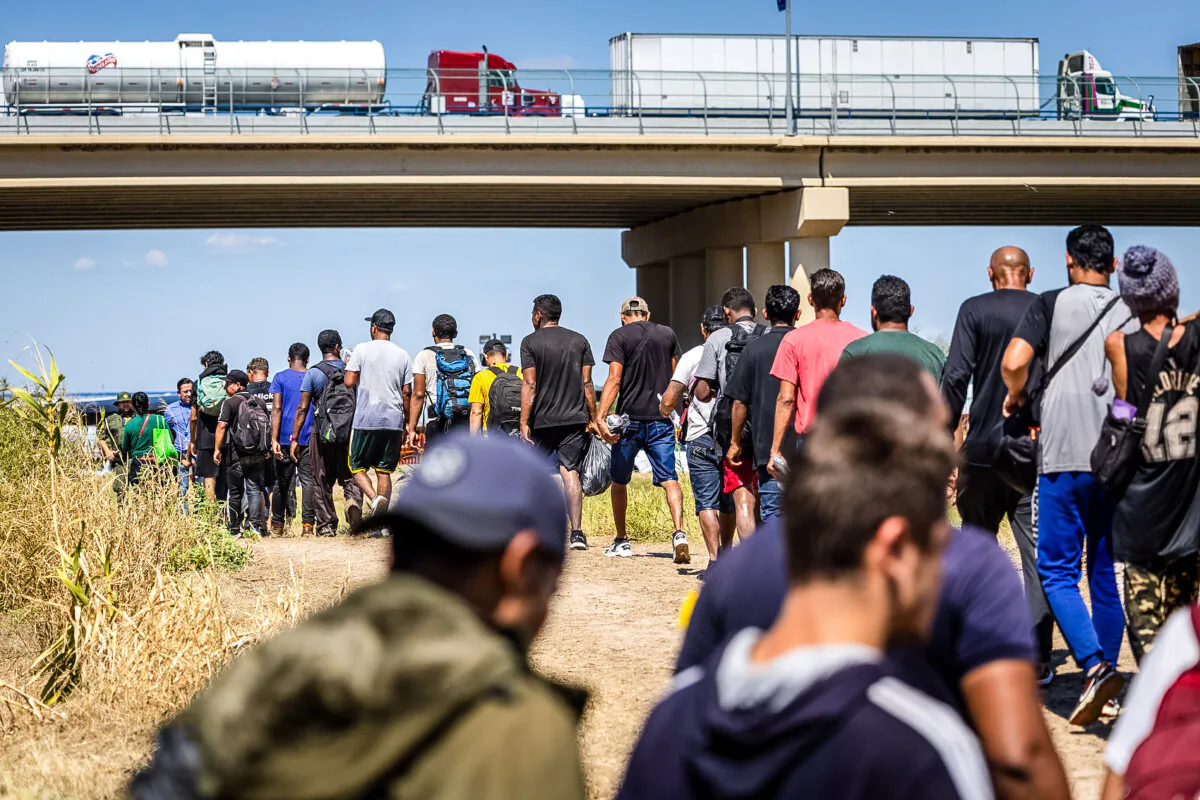 Immigrants walk towards a U.S. Border Patrol checkpoint after crossing the U.S.-Mexico border, in Eagle Pass, Texas, on Sept. 28, 2023. (John Moore/Getty Images)