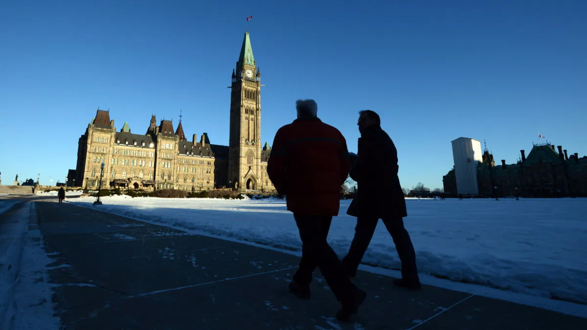 Two people walk toward the Centre Block on Parliament Hill in Ottawa, in a file photo. (The Canadian Press/Sean Kilpatrick)