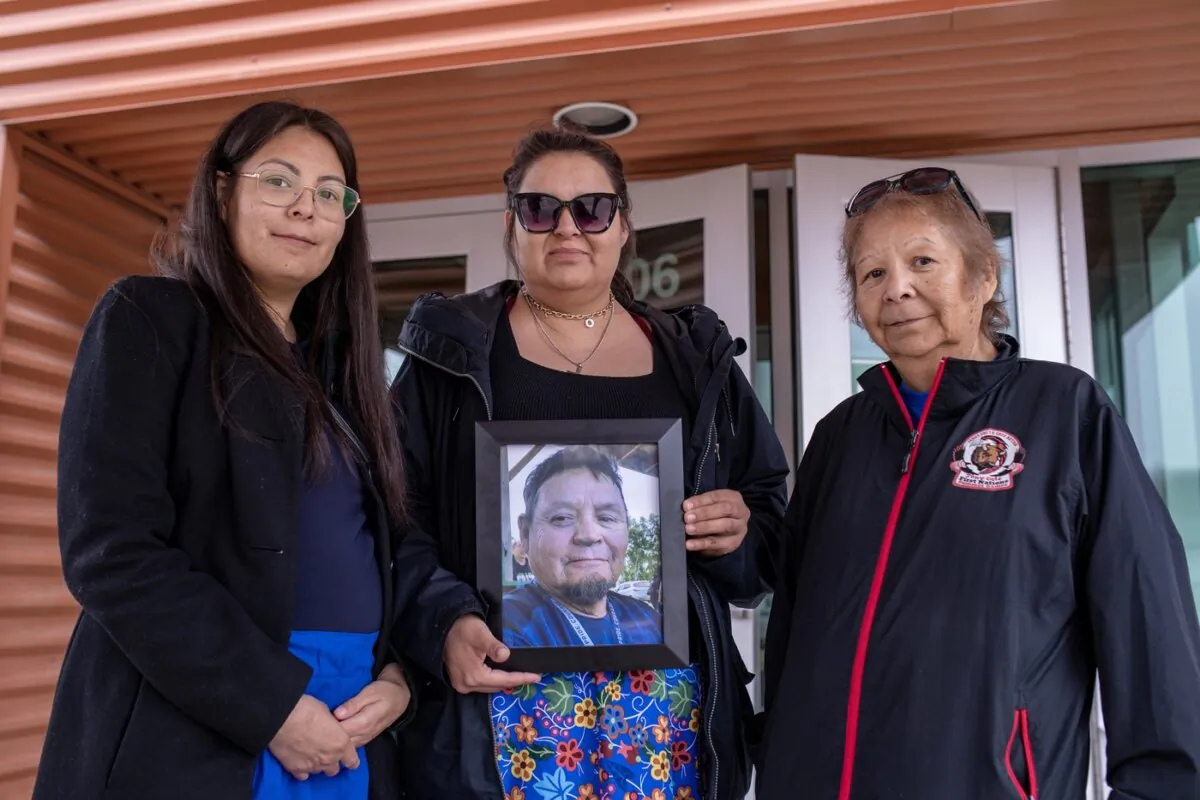 (L-R) Earl Burns’ daughters Deborah Burns and Vanessa Burns, and his wife Joyce Burns, hold a photograph of Mr. Burns during a Saskatchewan RCMP media event in Melfort, Sask., on April 27, 2023. (The Canadian Press/Liam Richards)