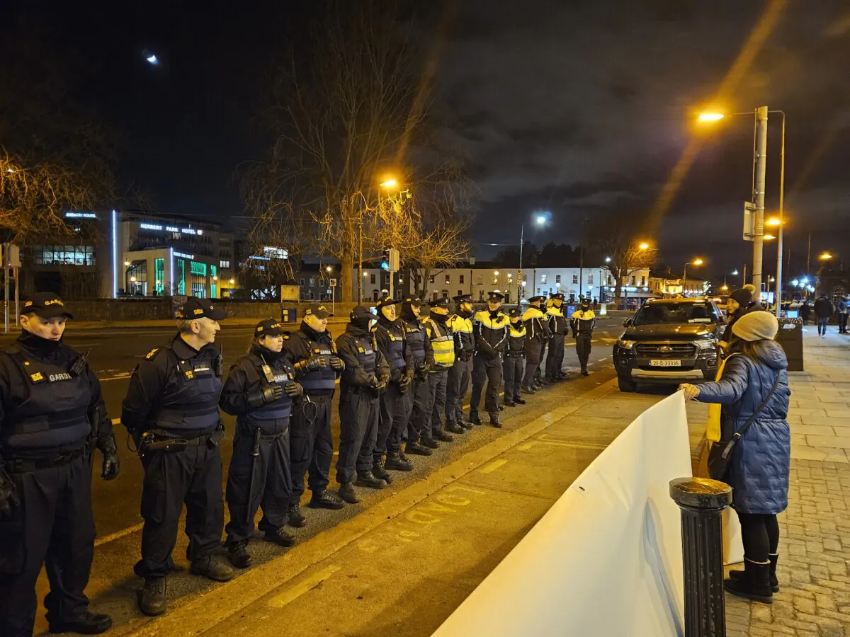 A group of police officers facing Falun Gong practitioners who were holding banners near a hotel where a Chinese delegation, led by Premier Li Qiang, was staying in Dublin, Ireland, on Jan. 16, 2024. (Irish Falun Dafa Association)