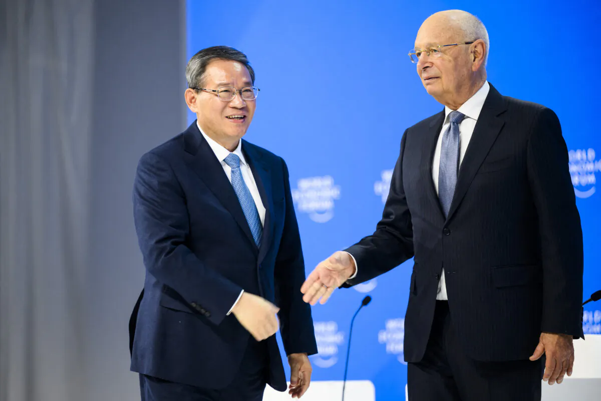 China's Prime Minister Li Qiang (L) and German Klaus Schwab, founder and executive chairman of the World Economic Forum, during a plenary session in the Congress Hall at the 54th annual meeting of the World Economic Forum in Davos, Switzerland, on Jan. 16, 2024. (LAURENT GILLIERON/POOL/AFP via Getty Images)