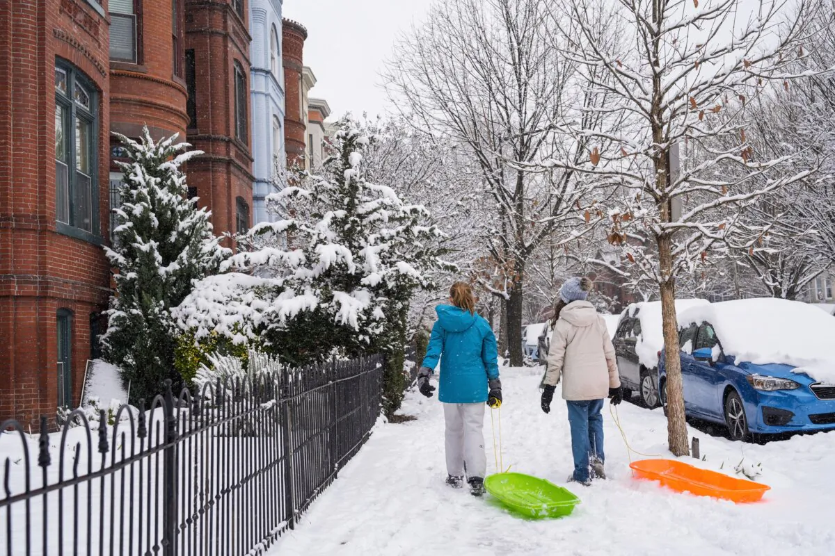 Girls walk through the Capitol Hill neighborhood dragging sleds as school was cancelled due to snow in Washington on Jan. 19, 2024. (Jacquelyn Martin/AP Photo)
