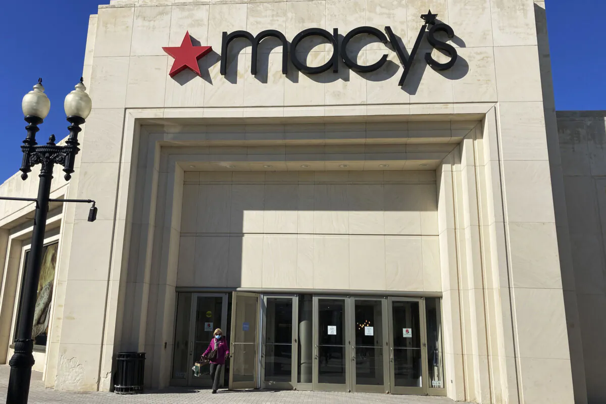 A shopper exits Macy's at the Woodfield Old Orchard Shopping Center in Skokie, Ill., on Feb. 19, 2022. (Nam Y. Huh/AP Photo)