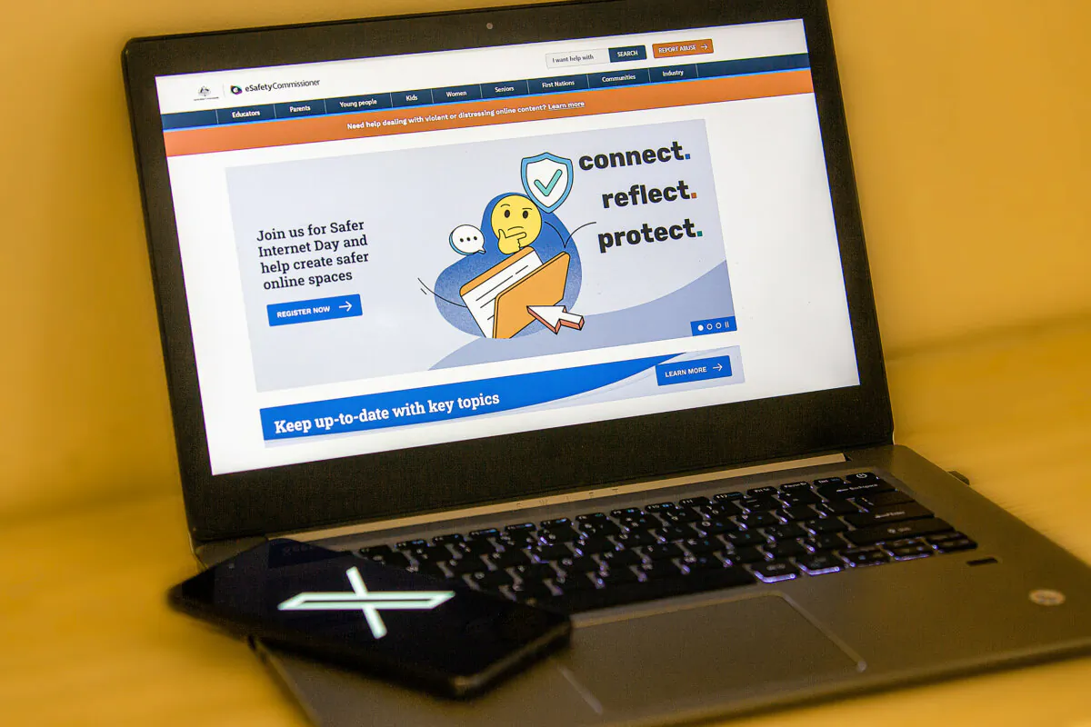 An image of the X (formerly Twitter) phone app in front of a laptop featuring the front page to Australia's eSafety commissioner website, taken in Perth, Western Australia on Jan. 22, 2024. (Wade Zhong/The Epoch Times)