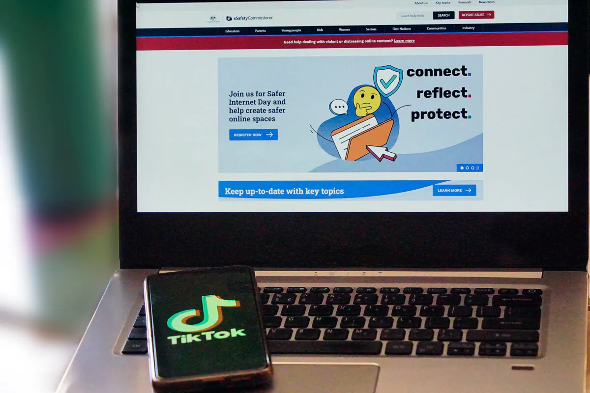 An image of the TikTok phone app in front of a laptop featuring the front page to Australia's eSafety commissioner website, taken in Perth, Western Australia on Jan. 20, 2024. (Wade Zhong/The Epoch Times)