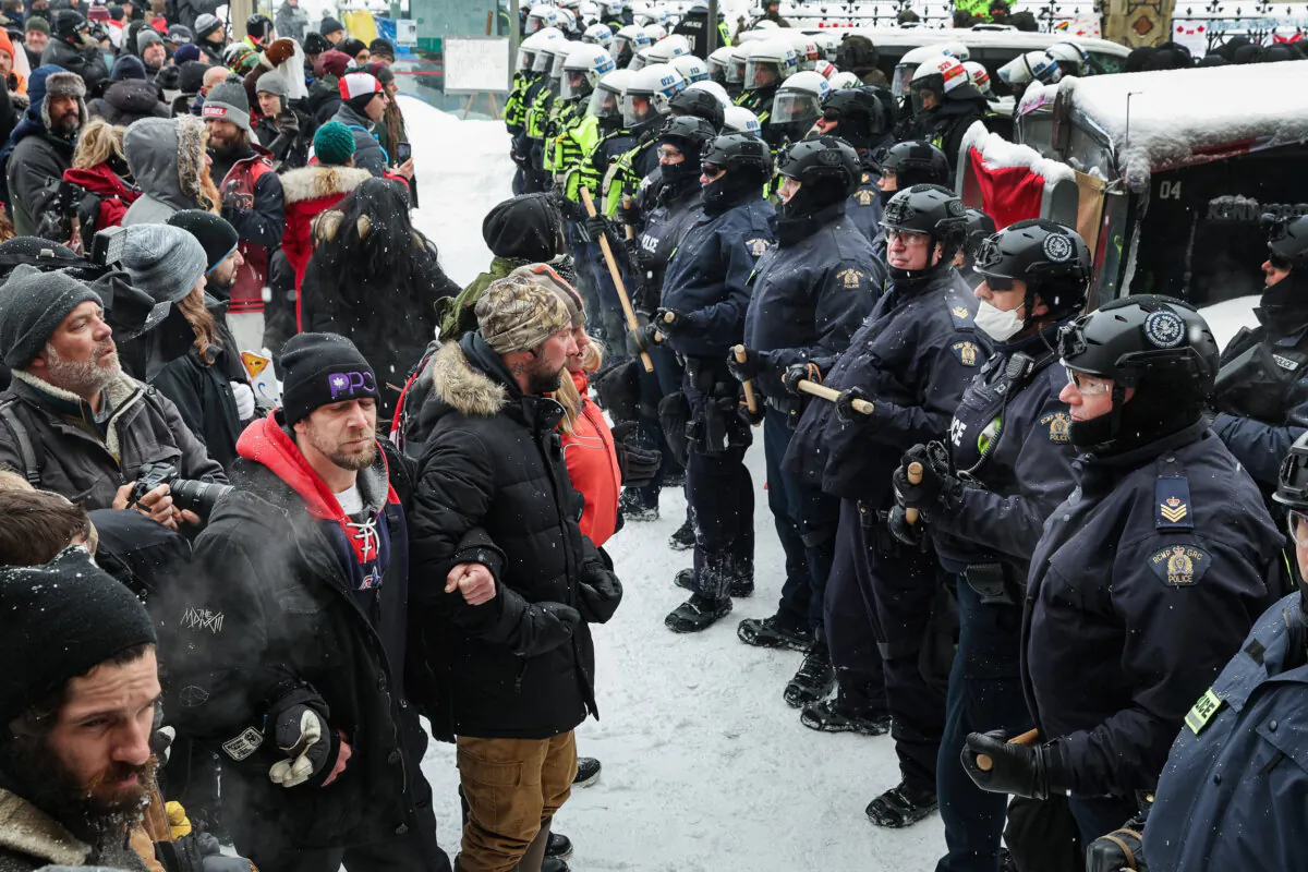 Police confront participants of the Freedom Convoy protest after the Emergencies Act was invoked, on Feb. 19, 2022. (Scott Olson/Getty Images)