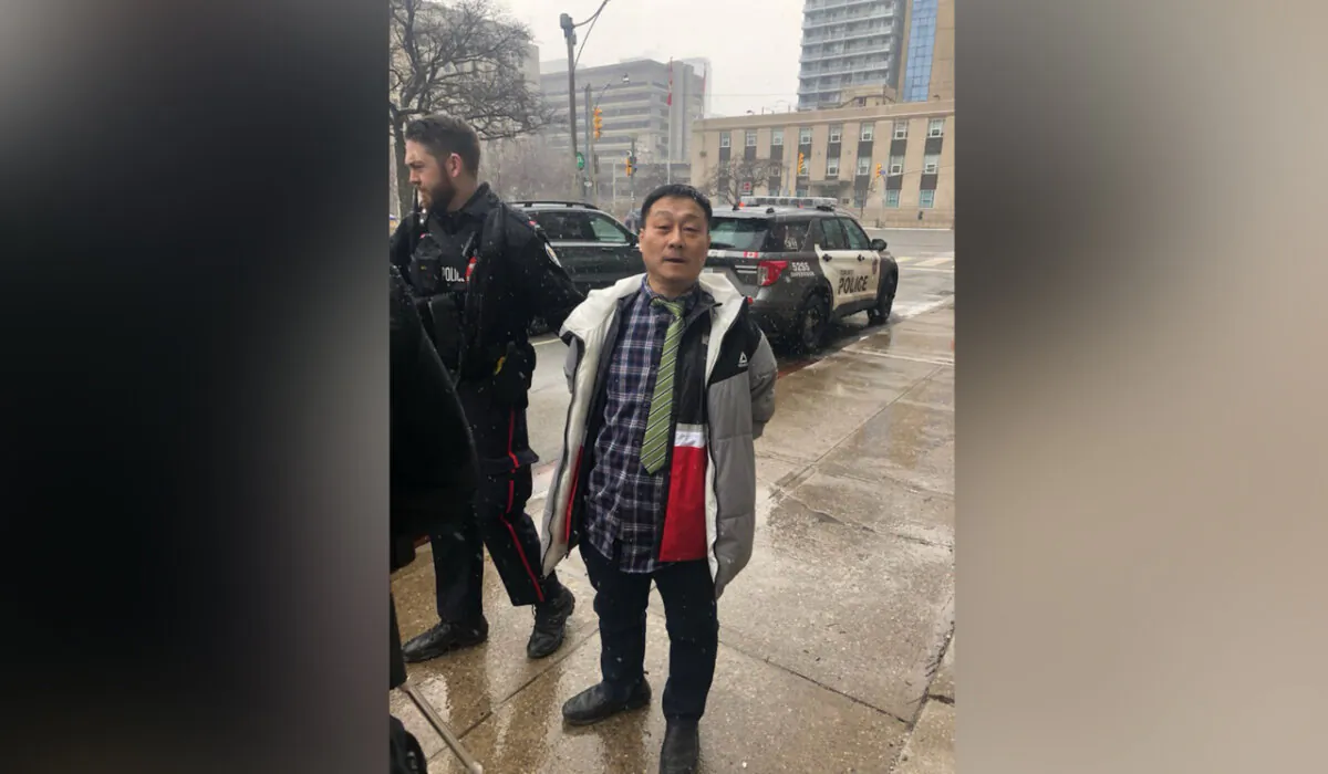 A Toronto man was arrested after allegedly attacking and vandalizing signs of Falun Gong practitioners outside of a building hosting a Chinese consulate visa application office on Jan. 23, 2024. (The Epoch Times)