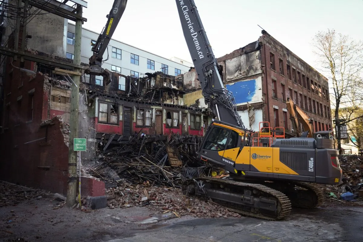 Debris falls to the ground as demolition resumes on the Winters Hotel after a body was found in the single room occupancy (SRO) building, in Vancouver, B.C., on April 22, 2022. (The Canadian Press/Darryl Dyck)