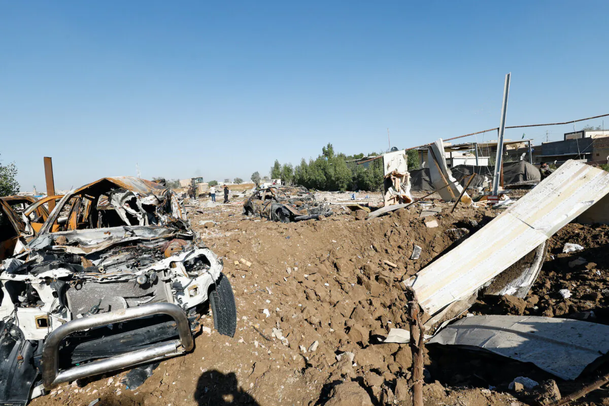 Debris lays near destroyed cars at the site of a U.S. airstrike, in Hilla, Iraq, on Dec. 26, 2023. (Reuters/Alaa al-Marjani)