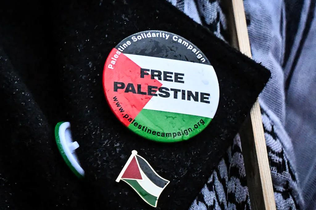 Badges picturing the Palestinian flag and reading a message in support of Palestinians, are pinned on the jacket of a protester outside Downing Street, in London, on Oct. 18, 2023. (Justin TALLIS/AFP via Getty Images)
