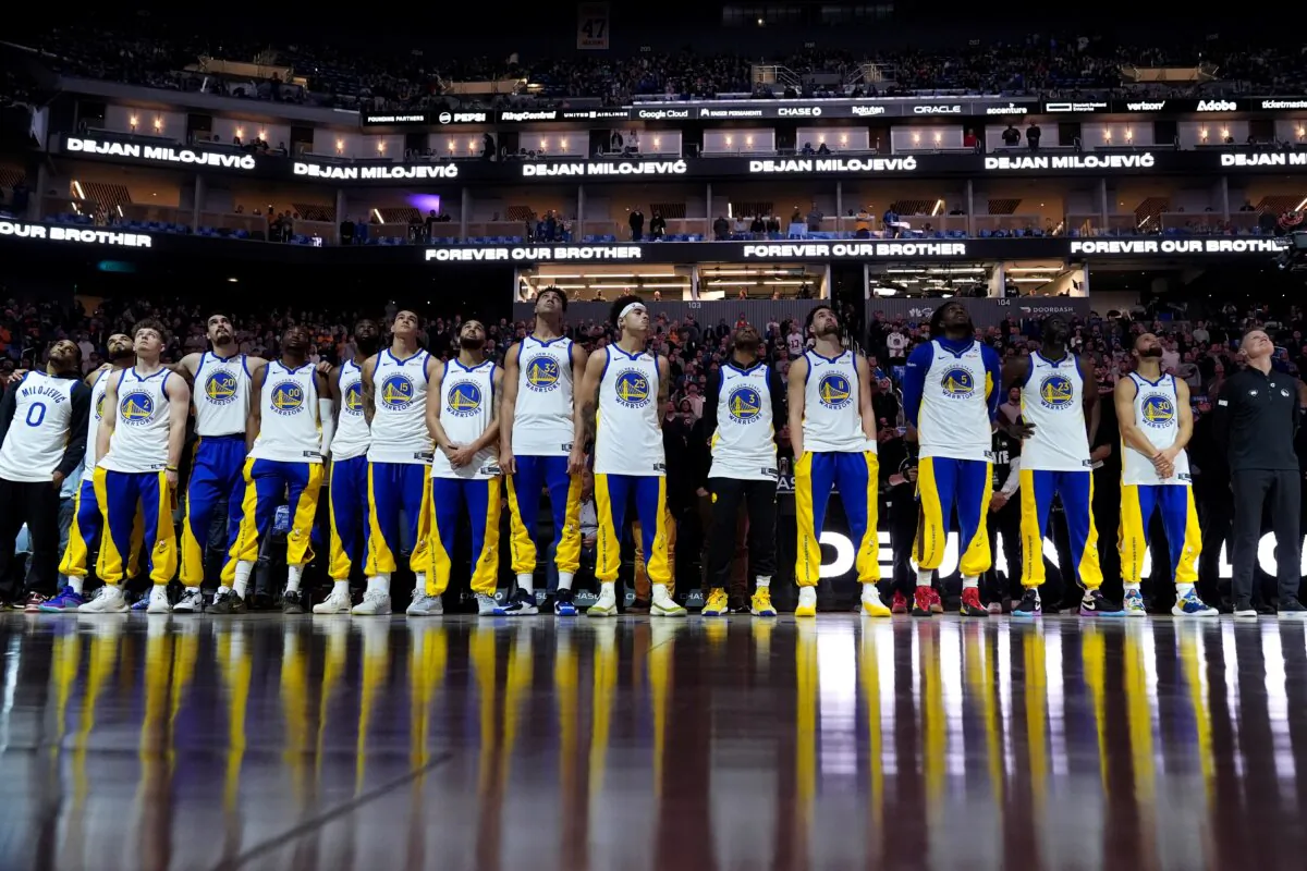 The Golden State Warriors watch a video tribute to late assistant coach Dejan Milojevic, who died Jan. 17 after suffering a heart attack, before an NBA basketball game against the Atlanta Hawks, in San Francisco on Jan. 24, 2024. (Godofredo A. Vásquez/AP Photo)