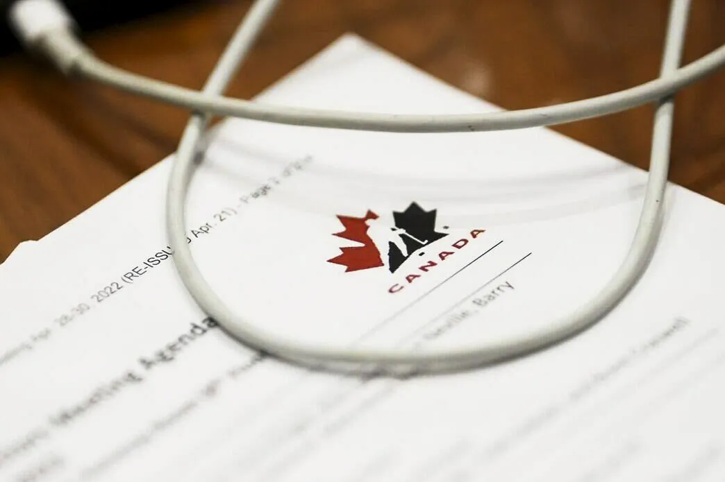 A Hockey Canada document is reviewed by a member of Parliament during a House of Commons Committee on Canadian Heritage looking into safe sport in Canada on Parliament Hill in Ottawa on Oct. 4, 2022. (Sean Kilpatrick/The Canadian Press)