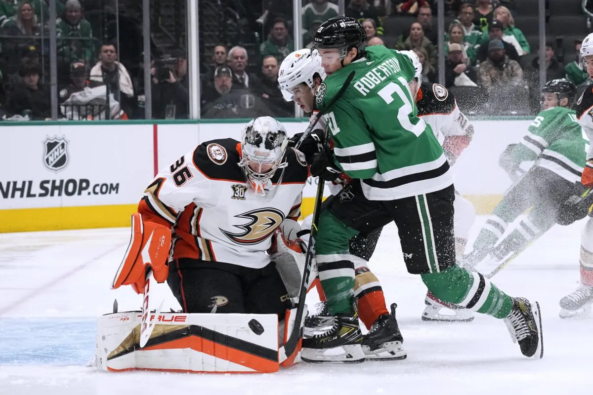 Anaheim Ducks goaltender John Gibson, gets help from defenseman Olen Zellweger (Rear) on a shot attempt by Dallas Stars left wing Jason Robertson (21) during the first period of an NHL hockey game in Dallas on Jan. 25, 2024. (Tony Gutierrez/AP Photo)