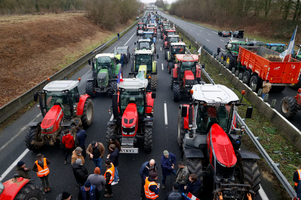 French farmers use their tractors to block the A1 highway as they protest over price pressures, taxes and green regulation, in Chamant, near Paris, France, on Jan. 26, 2024. (Abdul Saboor/Reuters)
