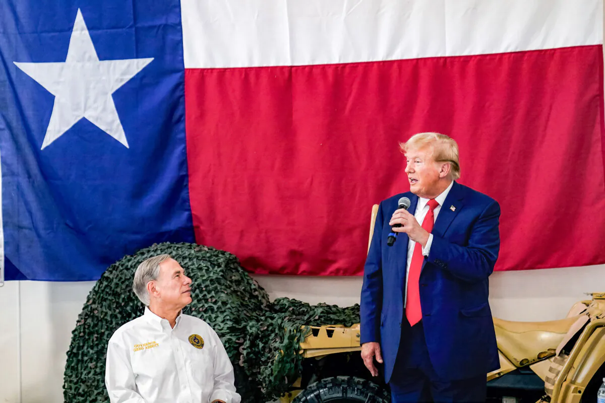 Texas Gov. Greg Abbott, left, listens as Republican presidential candidate and former President Donald Trump, right, speaks to Texas state troopers and guardsmen during a Thanksgiving meal at the South Texas International Airport, Sunday, Nov. 19, 2023, in Edinburg, Texas. (AP Photo/Eric Gay)