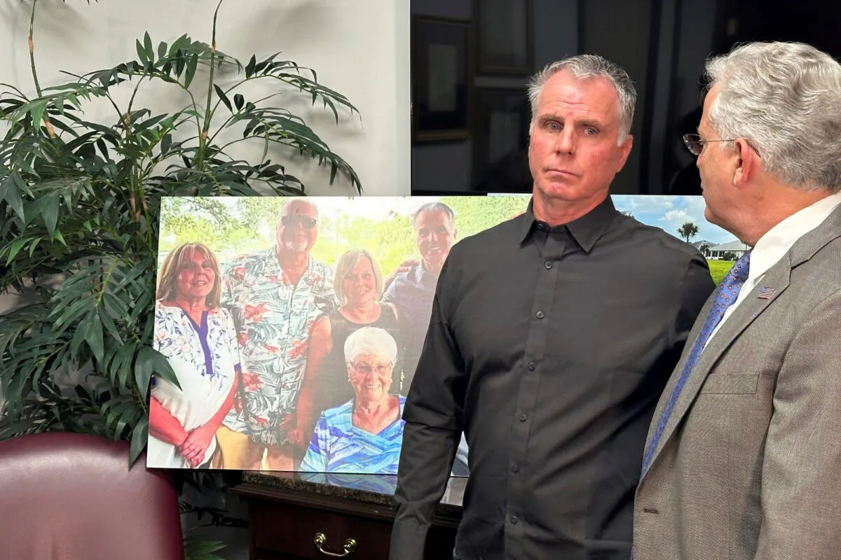 Bill Serge stands with his attorney Gary Lesser next to a photo of his mother, Gloria Serge, who was killed in an alligator attack, in West Palm Beach, Fla., on Jan. 25, 2024. (Terry Spencer/AP Photo)
