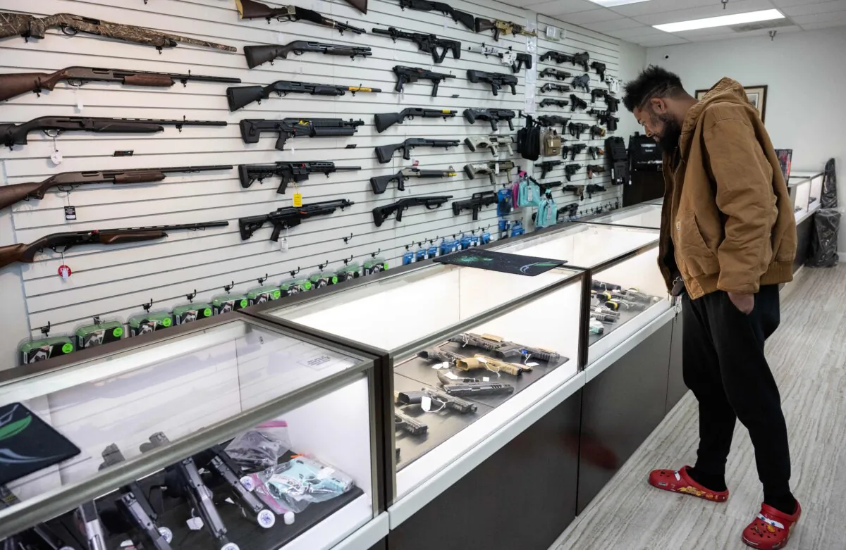 Jordan Landis, a gun collector, looks at guns in EJB's Gun Shop in Capitol Heights, Md., on March 14, 2023. (Andrew Caballlero-Reynolds/AFP via Getty Images)