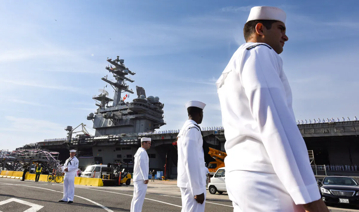 Members of the US Navy welcome aircraft carrier USS Ronald Reagan as she arrives at the US Navy base in Yokosuka, a suburb of Tokyo, on Oct. 1, 2015. (Toru Yamanaka/AFP via Getty Images)
