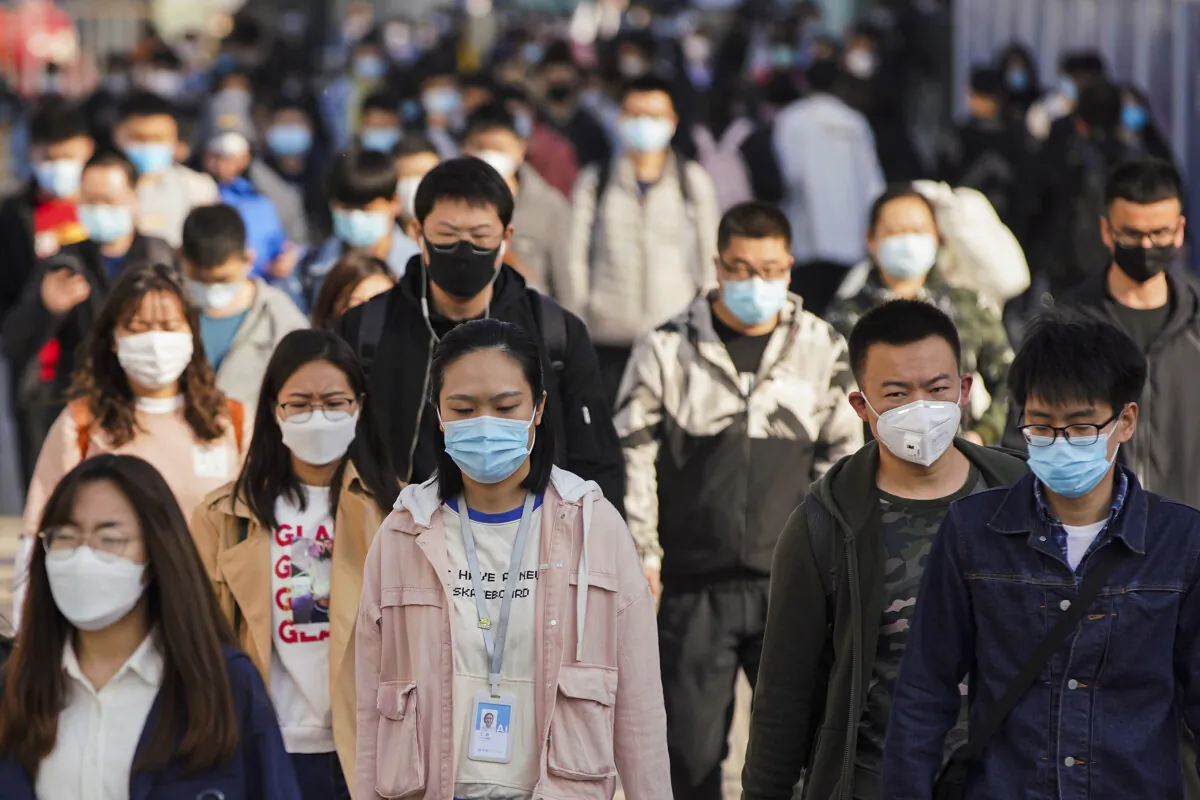 Commuters wear protective masks as they exit a train at a subway station during Monday rush hour in Beijing, China on April 13, 2020. (Lintao Zhang/Getty Images)