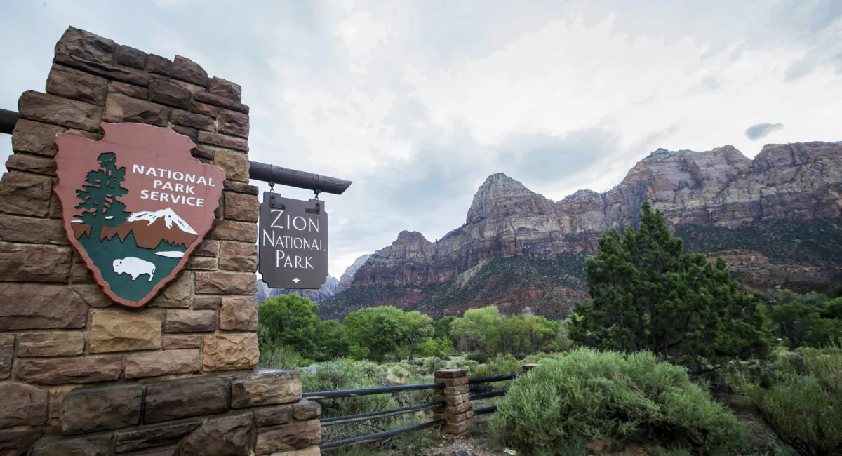 FILE - A sign hangs at Zion National Park on Tuesday, Sept. 15, 2015, near Springdale, Utah. A hiker has died of a suspected heart attack in Utah's Zion National Park. The National Park Service said the man was found unresponsive on the West Rim Trail near Scout Lookout on Friday, Jan. 27, 2024. (AP Photo/Rick Bowmer, File)