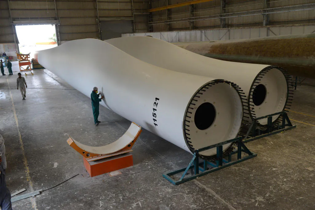 An Indian worker checks wind turbine blades at Rotor Blade Manufacturing facility of Suzlon Energy Limited at Paddhar village near Bhuj, some 400 kms from Ahmedabad, on June 26, 2015. (Sam Panthaky/AFP via Getty Images)