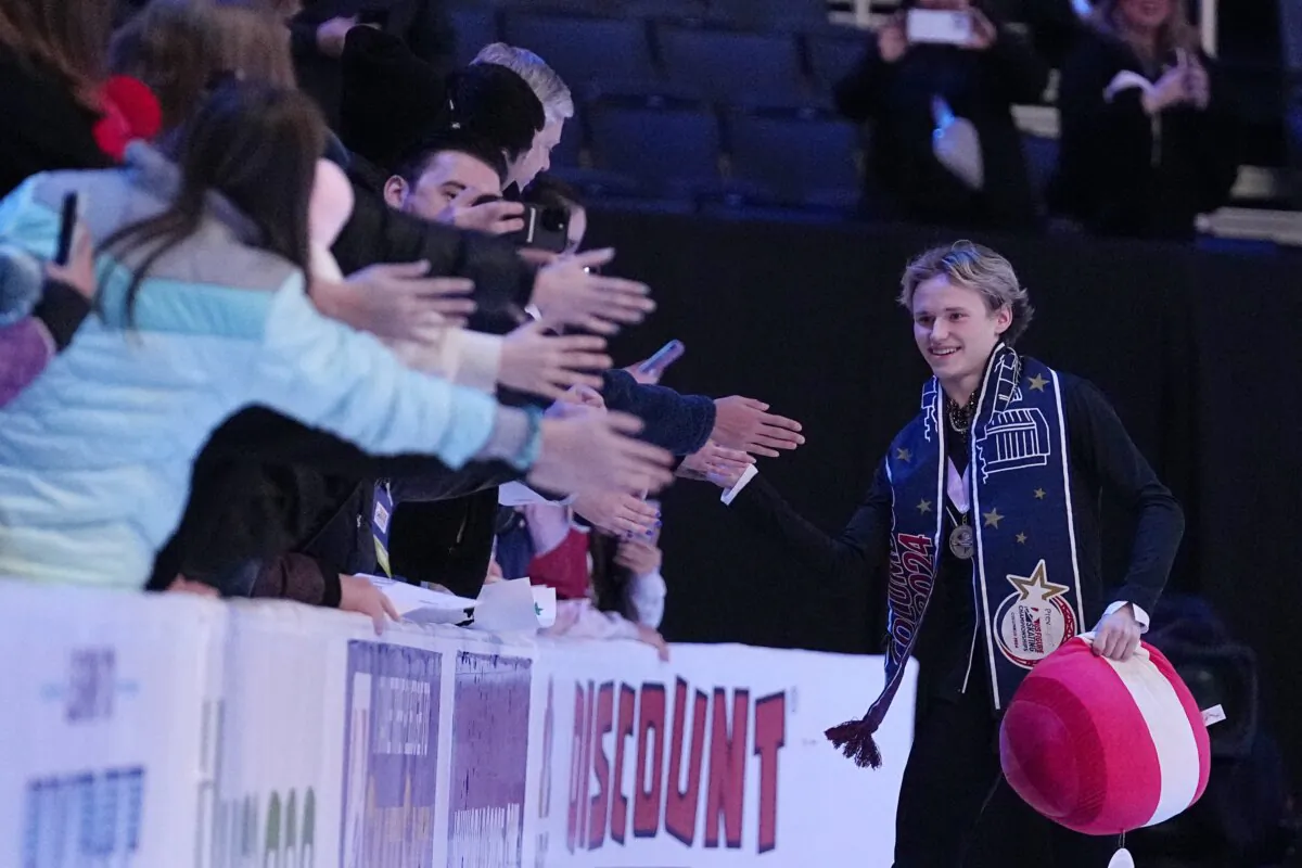 Ilia Malinin (R) celebrates with fans at the U.S. figure skating championships in Columbus, Ohio, on Jan. 28, 2024. (Sue Ogrocki/AP Photo)