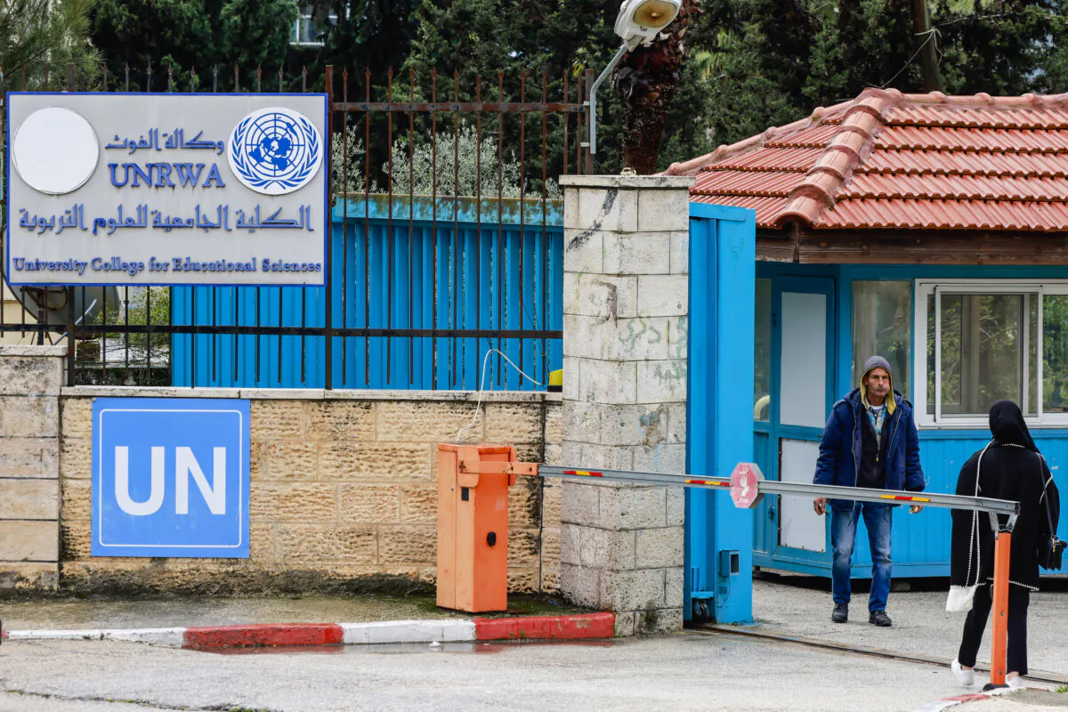 Palestinians stand at the entrance of the UNRWA-run University College for Educational Science Ramallah city in the occupied West Bank on January 29, 2024. UN Secretary-General Antonio Guterres pleaded for continued support for UNRWA, the United Nations agency for Palestinian refugees, which is threatened by a fierce row over alleged staff involvement in Hamas's October 7 attack that started the war. (Photo by Jaafar ASHTIYEH / AFP) (Photo by JAAFAR ASHTIYEH/AFP via Getty Images)
